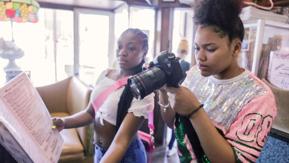 Young women learning filmmaking with professional camera equipment